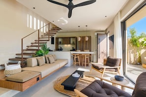 A modern living space with a staircase, a kitchen area, and a seating area with a view to the outdoors. - Villa Terra Mare Zephyr by Villa Plus (Ialysos)