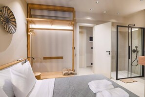 A modern bedroom with a bed, a walk-in closet, and a glass shower area. - Villa Terra Mare Zephyr by Villa Plus (Ialysos)