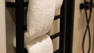A black towel rack with two white towels.