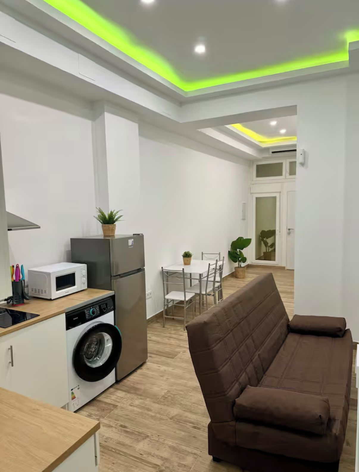 A compact living space with a kitchenette, a dining area, and a seating area.