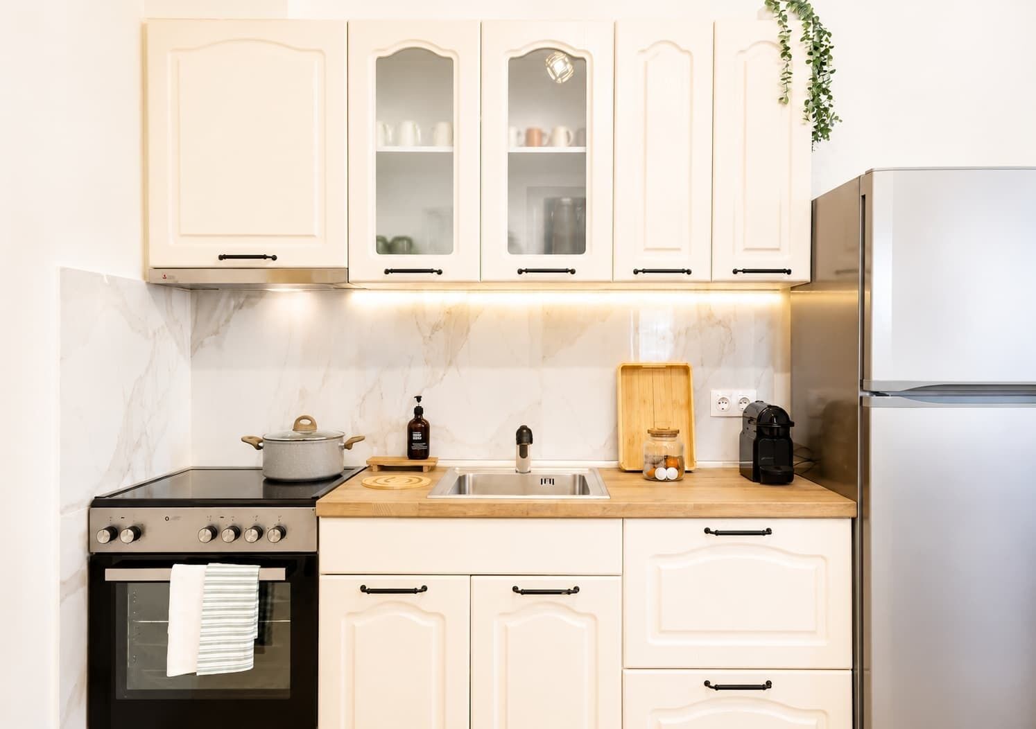 Eine Küche mit Herd, Backofen, Spüle und Kühlschrank.