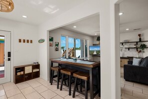 A modern kitchen with a bar area, large windows, and a view of the outdoors. - Luxury waterfront retreat: Private Pool & SPI views (Port Isabel)