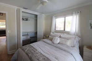 A bedroom with a bed, a desk, and a walk-in closet. - Heated pool, Putting Green, propane fire pit, outdoor shower waterfront home 4 U (Palm Beach Gardens)