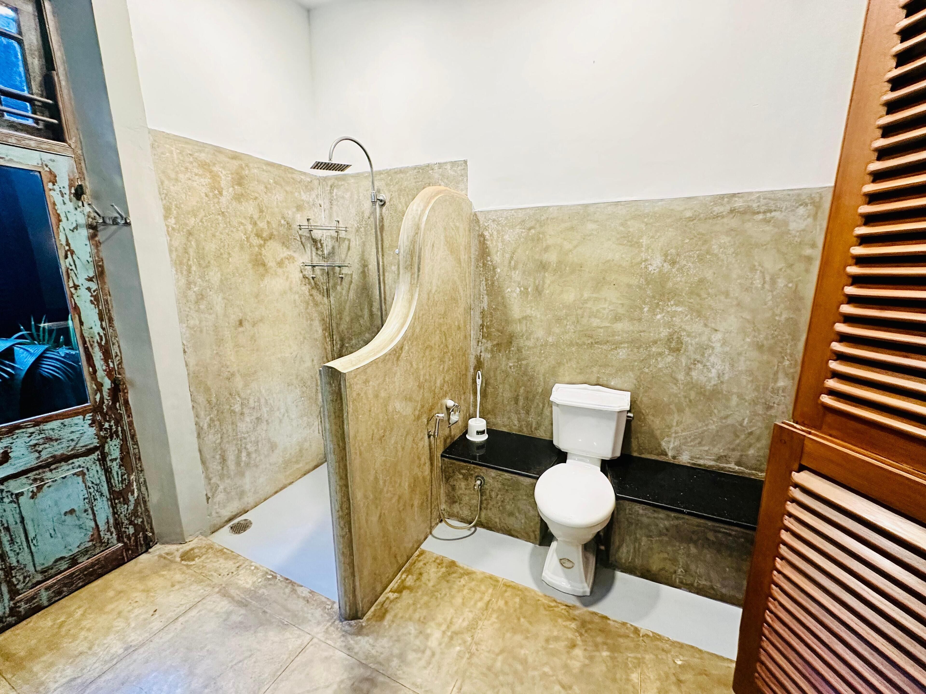 A bathroom with a shower, toilet, and a sink.