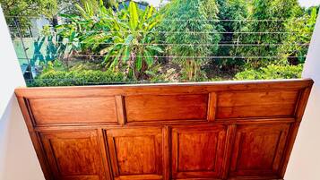 Un banco de madera con vistas a un jardín con diversas plantas y un edificio al fondo.