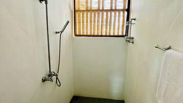 A small, narrow shower room with a window, a towel rack, and a ceiling vent.