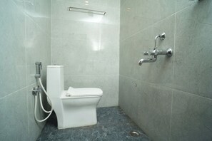 A small, modern bathroom with a toilet, a shower, and a sink. - PTR RESIDENCY&ROOMS (Tiruvannamalai)