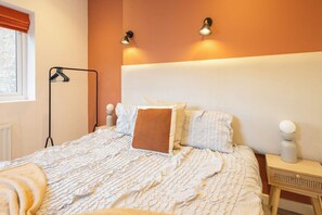 A bedroom with a bed, bedside lamps, a nightstand, and a window with curtains. - Boutique Eastbourne Gem (Eastbourne)