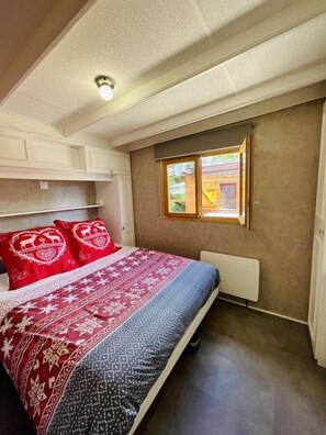Ein Schlafzimmer mit einem Bett, einem Fenster und einer Heizung.