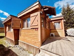 Eine Holzhütte mit überdachter Veranda, einer kleinen Stufe und einem Schild mit der Nummer 89.