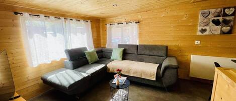 A cozy cabin interior with a sofa, a small round table, and a radiator.
