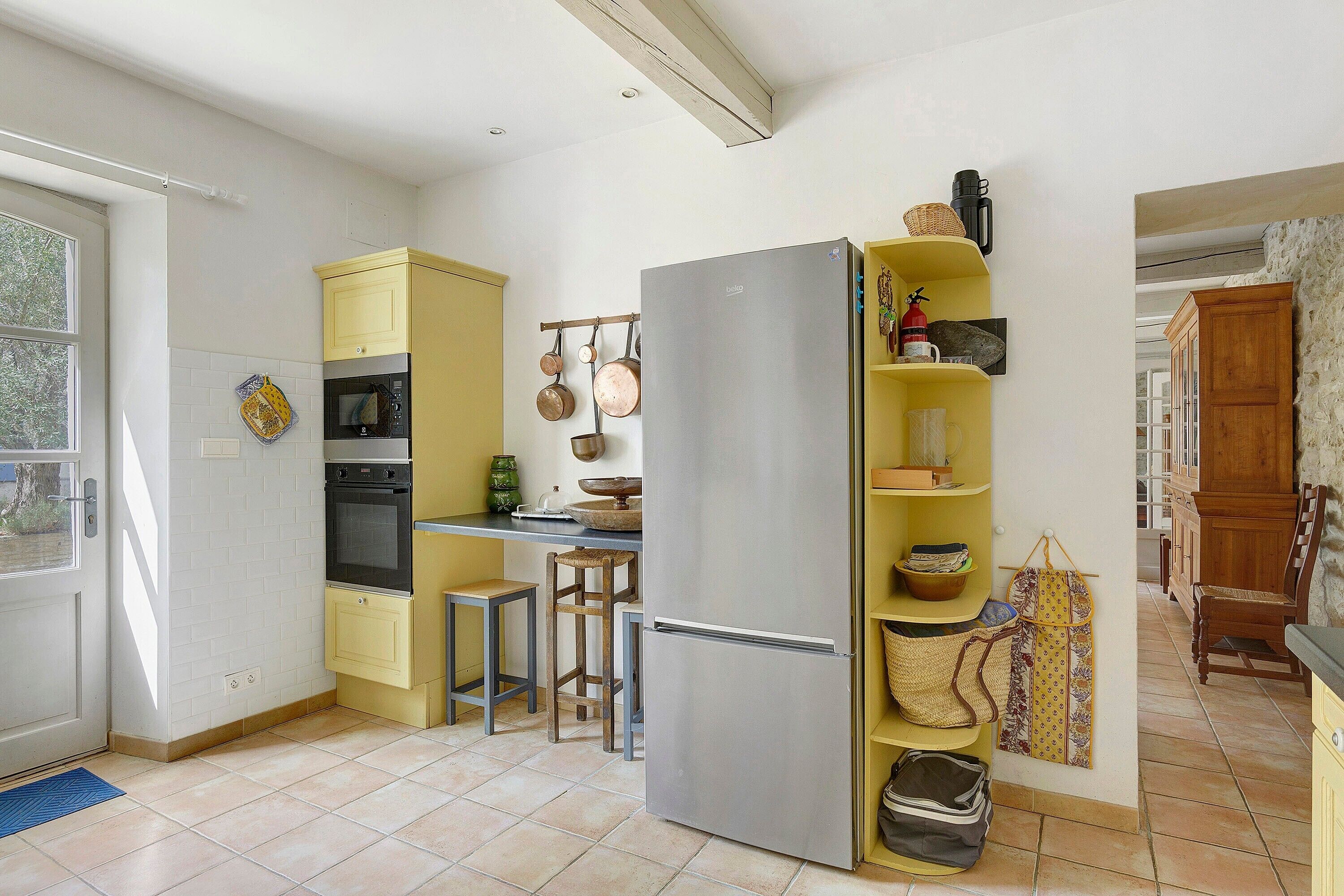 Eine kompakte Küche mit integriertem Backofen, einem Kühlschrank und einer kleinen Essecke.