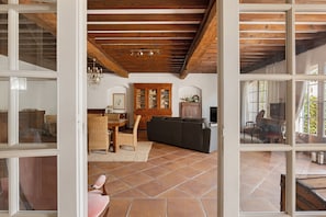 An open-plan living area with a dining table, chairs, a sofa, and a cabinet. - Holiday home 'Gîte Palmier - Le Trabet' with pool in the heart of the vineyards (Moussoulens)