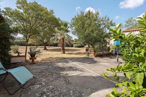 A courtyard with trees, a bench, and a small building. - Holiday home 'Gîte Palmier - Le Trabet' with pool in the heart of the vineyards (Moussoulens)