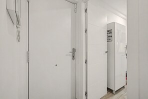 A hallway with a white door, a white cabinet, and a sign with motivational words. - Apartment 'Playa Torrecilla' with Sea View, Wi-Fi and Air Conditioning (Nerja)