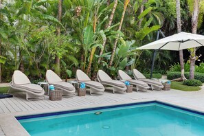 Un espace aménagé au bord de la piscine, avec des chaises longues et une piscine.