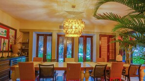 A dining area with a checkered floor, wicker chairs, and a central table. - Tortuga C17Luxury Villa Punta Cana  (Higüey)