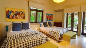 A bedroom with two beds, a nightstand, a desk, and a window with a view of greenery. - Tortuga C17Luxury Villa Punta Cana  (Higüey)