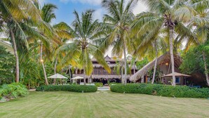 A resort with a central building, palm trees, and a well-maintained lawn. - Tortuga C17Luxury Villa Punta Cana  (Higüey)