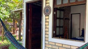 A brick building with a hammock, a door, and a window.