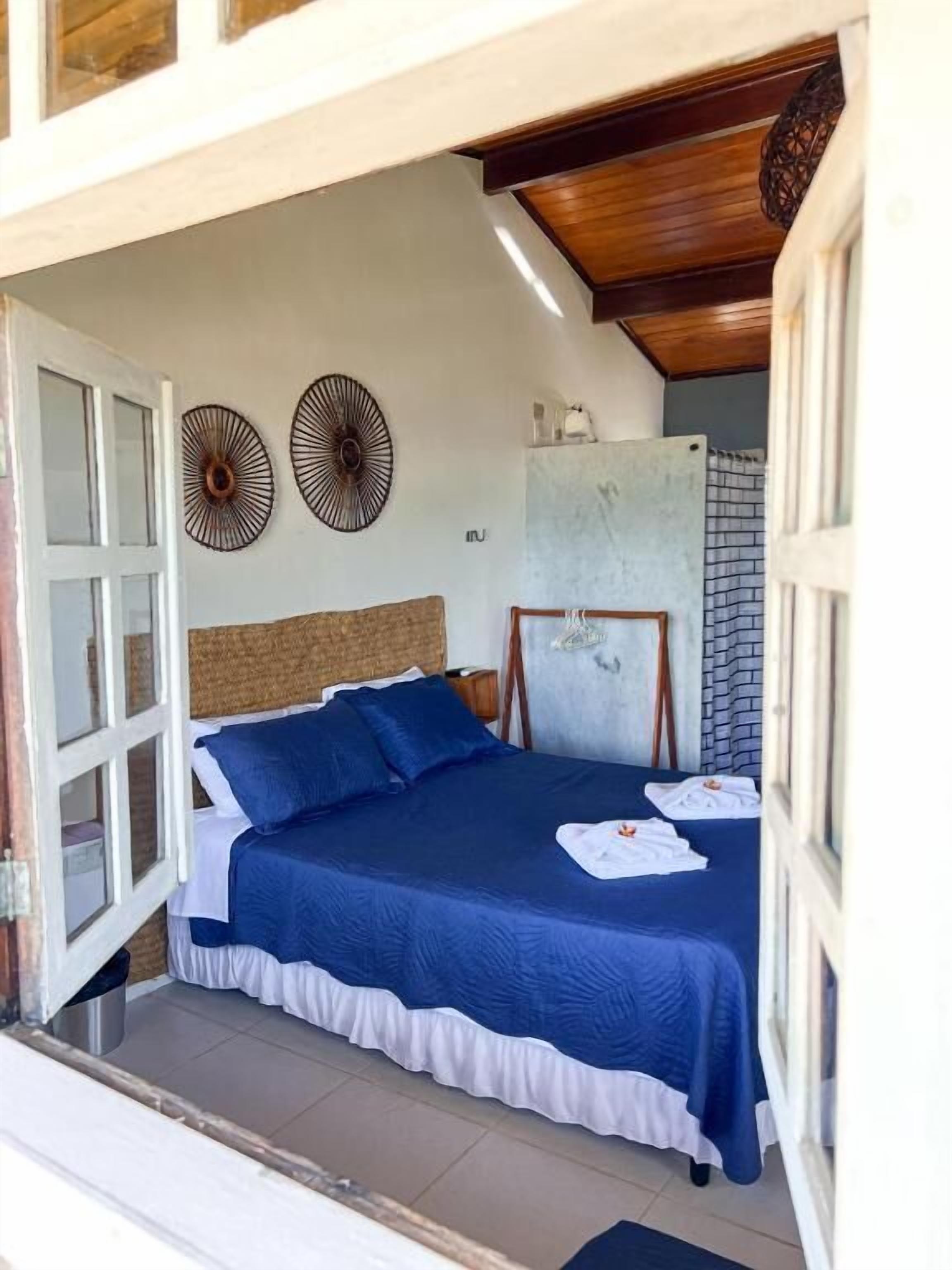 A bedroom with a bed, two wall decorations, a window, and a door.