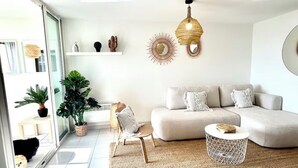 Un salon moderne avec un canapé, une table basse ronde et un grand tapis tissé.