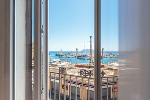 A view through a window of a marina with boats, buildings, and a clear sky. - Igiea Florio Sea View Apartments by Wonderful Italy (Palermo)