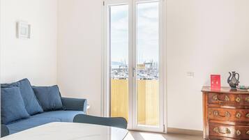 Una habitación con un sofá, una mesa de comedor y un aparador de madera con cajones.