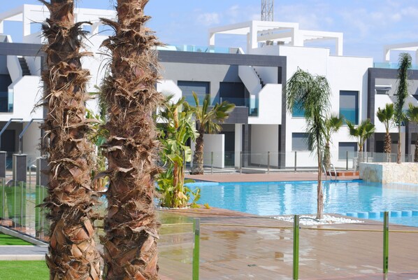 Ein modernes Gebäude mit Pool und Palmen.