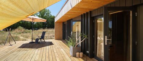 A wooden deck with a seating area and a large umbrella.