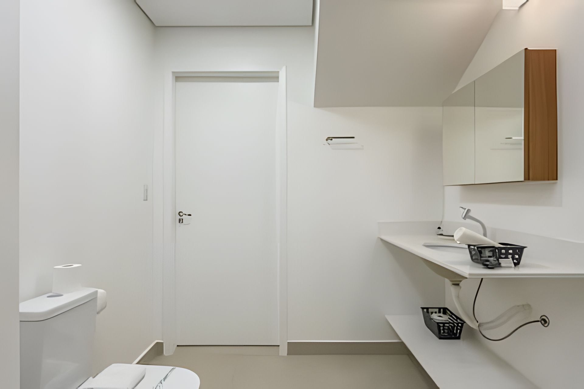 A modern bathroom with a toilet, sink, and mirror.