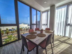 A dining area with a view of the city and ocean, featuring a table with placemats and chairs. - House in Gran Canaria Near Playa de Las Canteras (Las Palmas de Gran Canaria)