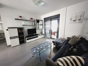 A modern living room with a TV, sofa, and coffee table. - Groundfloor Oasis Beach I La Zenia (Orihuela)