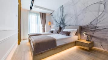 A modern bedroom with a large bed, bedside tables, and a wall art piece.