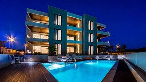 A modern hotel with a rooftop pool, multiple balconies, and outdoor seating. - Rocca Riviera  (Umag)