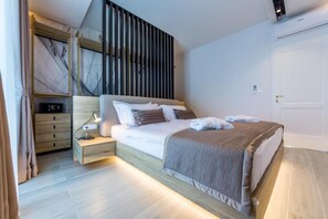 Un dormitorio moderno con cama, mesita de noche y velador.