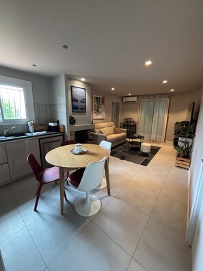 A modern kitchen with a dining area, a sofa, and a coffee table.