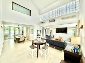 A spacious living area with a dining table, sofa, and TV. - Villa Gaviota with private pool by Otium (Hato Candal)
