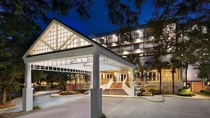 A hotel entrance with a covered walkway, a staircase leading to the building, and a landscaped area with trees. - 2 Bedroom Villa Harbour Club Resort w/ Amenities (Hilton Head Island)