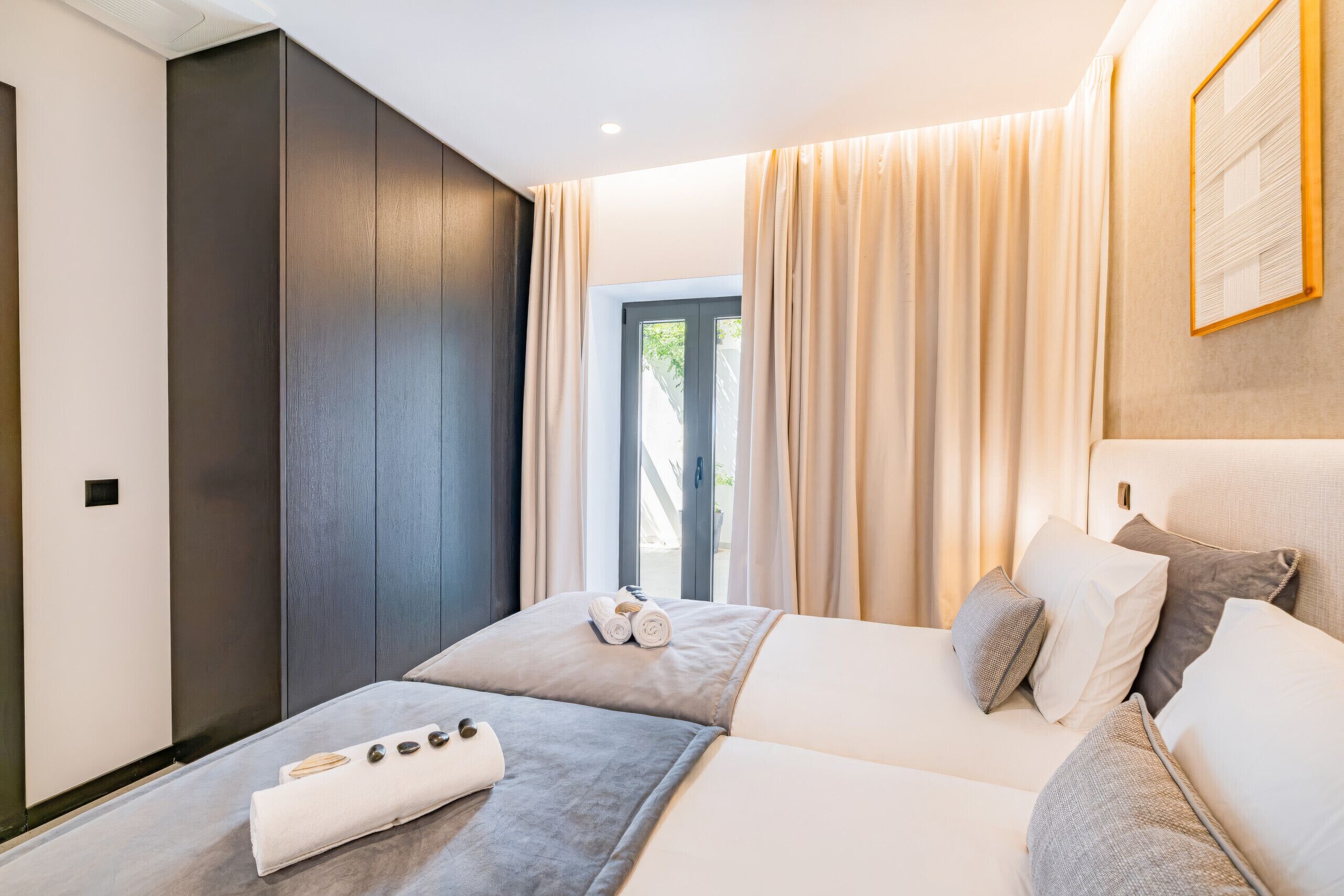 Ett modernt hotellrum med en säng, ett sidobord och utsikt över omgivningarna.