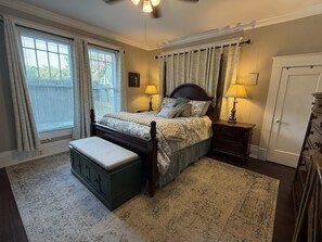 A bedroom with a bed, two bedside tables, a bench, a dresser, and a door. - Anchored in Paradise, Walk to Beach & Island View Casino (Gulfport)