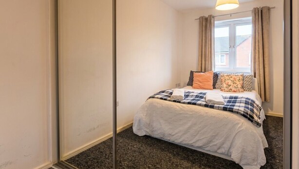 Une chambre à coucher avec un lit, des rideaux et une fenêtre.