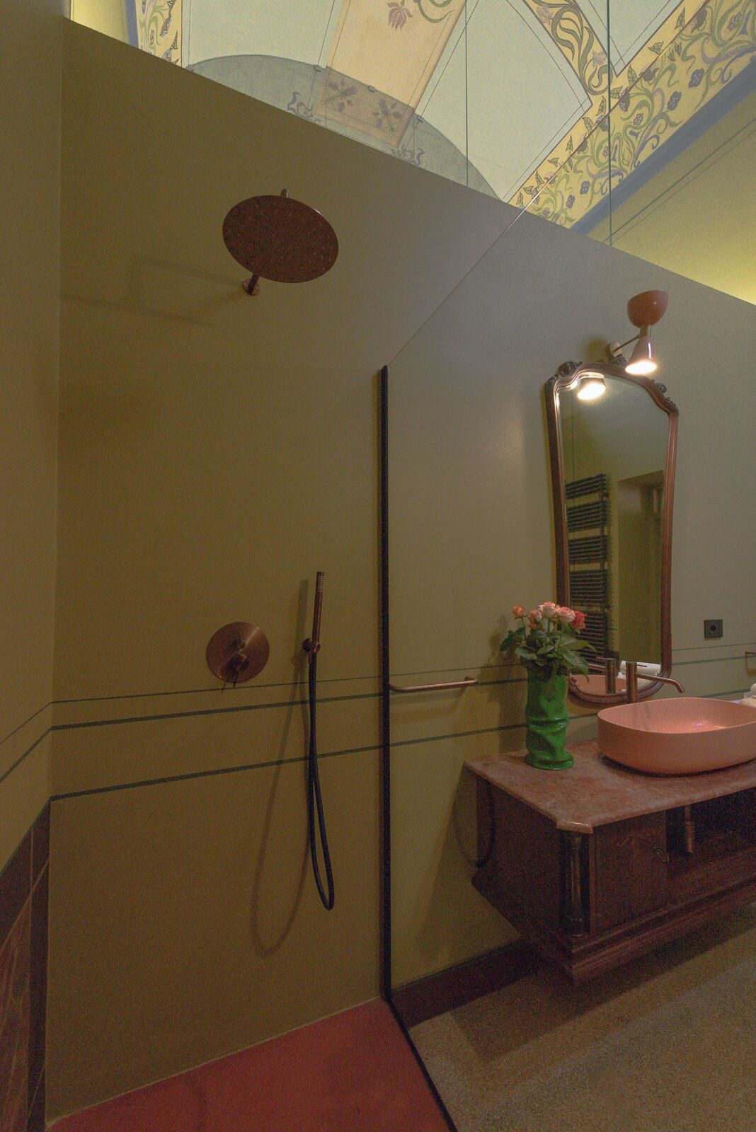A bathroom with a large mirror, a sink, a shower, and a towel rack.