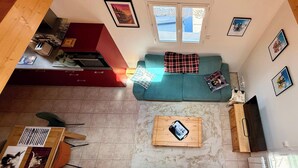 A spacious living area with a sofa, a coffee table, and a kitchen in the background. - La Pergola Le Mont Dore (6 people) (Mont-Dore)