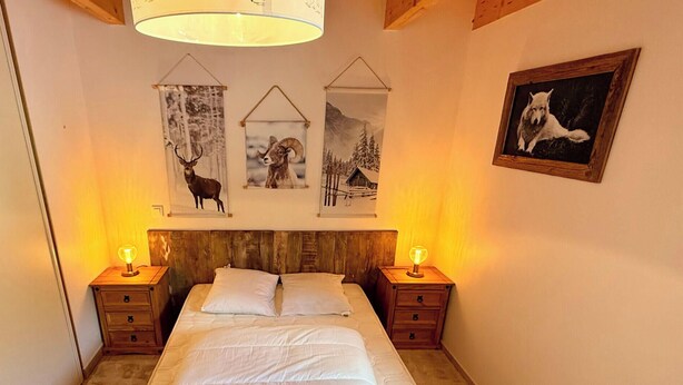 A bedroom with a wooden headboard, two bedside tables with lamps, a bed with white bedding, and three framed pictures on the wall depicting wildlife. - La Pergola Le Mont Dore (6 people) (Mont-Dore)