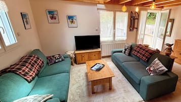 A cozy living room with a sofa, a television, and a coffee table.