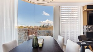 A modern dining area with a city view, a stone wall, and a wooden fence. - The Sandstone, Neutral Bay (Neutral Bay)