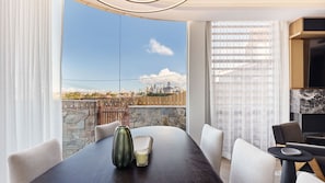 Ein moderner Essbereich mit Stadtblick, einer Steinwand und einem Holzzaun.