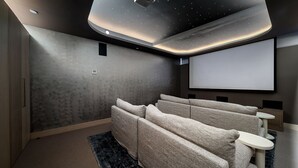 A home theater room with a large screen, comfortable seating, and a modern ceiling design. - The Sandstone, Neutral Bay (Neutral Bay)
