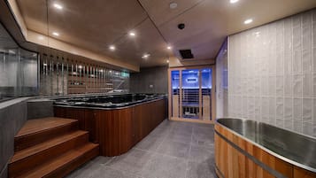 Une cuisine moderne dotée d’un îlot central, d’un escalier en bois et d’une cloison en verre.